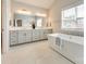 Relaxing bathroom featuring double sinks, soaking tub, and a large window bringing in lots of light at 509 Abelia Ln, Tega Cay, SC 29708
