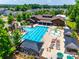 Aerial view of a community pool with sun loungers, covered seating, and a splash area surrounded by lush landscaping at 509 Abelia Ln, Tega Cay, SC 29708