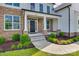 Inviting stone and siding porch with green wreath and manicured landscaping at 509 Abelia Ln, Tega Cay, SC 29708