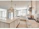 Bright, modern kitchen features island with stone countertops and stainless steel appliances at 509 Abelia Ln, Tega Cay, SC 29708