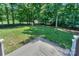Large backyard with healthy green grass slopes away from a wood deck bordered by black iron fence at 5485 Deer Run Ct, Davidson, NC 28036