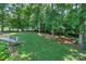 Beautiful backyard featuring a well-manicured lawn and lush trees creating a private, serene outdoor space at 5485 Deer Run Ct, Davidson, NC 28036