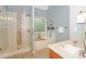 Bright bathroom featuring a glass-enclosed shower, soaking tub, and modern fixtures at 5485 Deer Run Ct, Davidson, NC 28036
