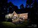 Back of house at dusk showing a deck, porch and exterior lights shining on the yard and stairs at 5485 Deer Run Ct, Davidson, NC 28036