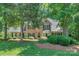 Beautiful brick home with mature landscaping, bay window and black shutters on a lush lawn at 5485 Deer Run Ct, Davidson, NC 28036