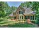 Stately brick home with lush lawn, mature trees, and lovely landscaping around the front entrance at 5485 Deer Run Ct, Davidson, NC 28036