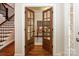 Hallway with staircase, hardwood floors, and a view of an office through glass-paned double doors at 5485 Deer Run Ct, Davidson, NC 28036