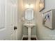 Charming powder room features pedestal sink, decorative mirror and elegant wall art at 5485 Deer Run Ct, Davidson, NC 28036