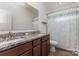 Bathroom features double vanity, granite countertop, large mirror, and shower with blue patterned curtain at 6007 Eleanor Rigby Rd, Charlotte, NC 28278