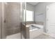 Bathroom featuring a glass-enclosed shower and a soaking tub next to a window at 6007 Eleanor Rigby Rd, Charlotte, NC 28278