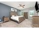 Cozy bedroom with a wooden bed frame, carpeted floors, ceiling fan, and ample natural light at 6007 Eleanor Rigby Rd, Charlotte, NC 28278