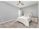 Cozy bedroom featuring carpeted floors, a queen-sized bed, a ceiling fan, and ample natural light at 6007 Eleanor Rigby Rd, Charlotte, NC 28278