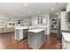 Open-concept kitchen with stainless steel appliances, island, and hardwood floors at 6007 Eleanor Rigby Rd, Charlotte, NC 28278