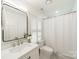 Bright bathroom featuring white vanity, modern fixtures, and a shower with a white shower curtain at 601 Cherokee Rd, Charlotte, NC 28207