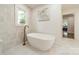 Elegant soaking tub with brass fixtures and a bright window at 601 Cherokee Rd, Charlotte, NC 28207