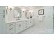 Bright bathroom with double sinks, white cabinetry, and marble flooring at 601 Cherokee Rd, Charlotte, NC 28207