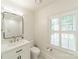 Bright bathroom featuring white vanity, modern fixtures, and a window with white shutters at 601 Cherokee Rd, Charlotte, NC 28207