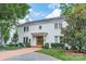 Charming two-story white brick home with mature trees, a brick driveway, and manicured landscaping at 601 Cherokee Rd, Charlotte, NC 28207