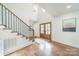 Bright foyer with hardwood floors, staircase with black iron railings, and double wood doors at 601 Cherokee Rd, Charlotte, NC 28207