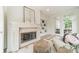 Bright living room featuring a stone fireplace, built-in shelves, and doors leading to the patio at 601 Cherokee Rd, Charlotte, NC 28207
