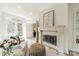 Bright living room featuring a stone fireplace, built-in shelves, and doors leading to the patio at 601 Cherokee Rd, Charlotte, NC 28207