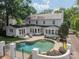 Backyard with a large inground pool, patio seating, lush landscaping, and a white brick fence at 601 Cherokee Rd, Charlotte, NC 28207