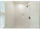 Shower showcasing sleek white tiling, modern fixtures, and built-in shelving for a luxurious experience at 601 Cherokee Rd, Charlotte, NC 28207