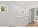Upstairs hallway with wood floors, multiple windows, white walls, and a linen closet at 605 Poplar St, Shelby, NC 28150