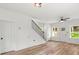 Open-concept living area with hardwood floors, stairs, a ceiling fan, and a front door at 605 Poplar St, Shelby, NC 28150