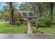 Charming two-story brick home with blue shutters surrounded by mature trees and lush landscaping at 6577 Stoney Ridge Rd, Matthews, NC 28104