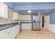 Cozy kitchen with white cabinets, stainless steel appliances, and blue walls and trim at 6577 Stoney Ridge Rd, Matthews, NC 28104