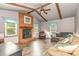 Inviting living room with a brick fireplace, exposed beams, vaulted ceiling, and wood-look floors at 6577 Stoney Ridge Rd, Matthews, NC 28104