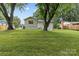 Expansive backyard featuring lush green grass and mature trees, offering a serene outdoor space at 7219 Brynhurst Dr, Charlotte, NC 28210