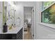 Bathroom vanity with gold fixtures, view to bedroom with neutral décor at 7219 Brynhurst Dr, Charlotte, NC 28210