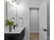 Modern bathroom with a sleek vanity, contemporary mirror and open doorway at 7219 Brynhurst Dr, Charlotte, NC 28210