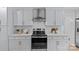 Close up of the white kitchen with an oven, white counters, and stainless steel handles at 7219 Brynhurst Dr, Charlotte, NC 28210