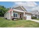 Cozy home with a welcoming front porch, American flag, and well-kept lawn at 7328 Strawberry Fields Ln, Charlotte, NC 28278