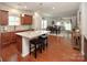 Open kitchen with a large center island and seating area, stainless steel appliances, and hardwood flooring at 7328 Strawberry Fields Ln, Charlotte, NC 28278