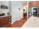 Kitchen area with stainless steel refrigerator, stone countertops, and wood cabinets leading to the hallway at 7328 Strawberry Fields Ln, Charlotte, NC 28278