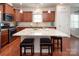 Well-lit kitchen featuring a center island, stainless steel appliances, wood cabinets and hardwood floors at 7328 Strawberry Fields Ln, Charlotte, NC 28278