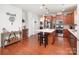 Open kitchen features island with seating, stainless steel appliances, and wood flooring at 7328 Strawberry Fields Ln, Charlotte, NC 28278