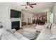 Inviting living room with fireplace, ceiling fan, and seamless flow into the dining area, perfect for entertaining at 7328 Strawberry Fields Ln, Charlotte, NC 28278