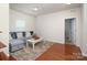Comfortable living room features hardwood floors, a gray sofa, and a view into the hallway at 7328 Strawberry Fields Ln, Charlotte, NC 28278