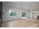 Open-concept living area with large windows, sliding glass doors, and a modern kitchen, all connected by light hardwood flooring at 823 32Nd Ne St, Conover, NC 28613
