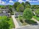 An aerial shot showcases a quaint single-story home with a long driveway surrounded by lush greenery and neighborhood at 8520 Mission Hills Rd, Charlotte, NC 28227