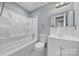 Updated bathroom features a bathtub with shower, toilet, vanity with sink and a large mirror at 8520 Mission Hills Rd, Charlotte, NC 28227