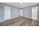 Bedroom with wood floors features two doors and a bright neutral color scheme at 8520 Mission Hills Rd, Charlotte, NC 28227