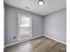 Cozy bedroom with hardwood floors, a window providing natural light, and neutral gray walls at 8520 Mission Hills Rd, Charlotte, NC 28227