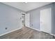 Spacious bedroom with hardwood floors, neutral gray walls, and an open doorway at 8520 Mission Hills Rd, Charlotte, NC 28227