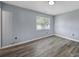 This bedroom features modern wood flooring and a bright window for natural light at 8520 Mission Hills Rd, Charlotte, NC 28227